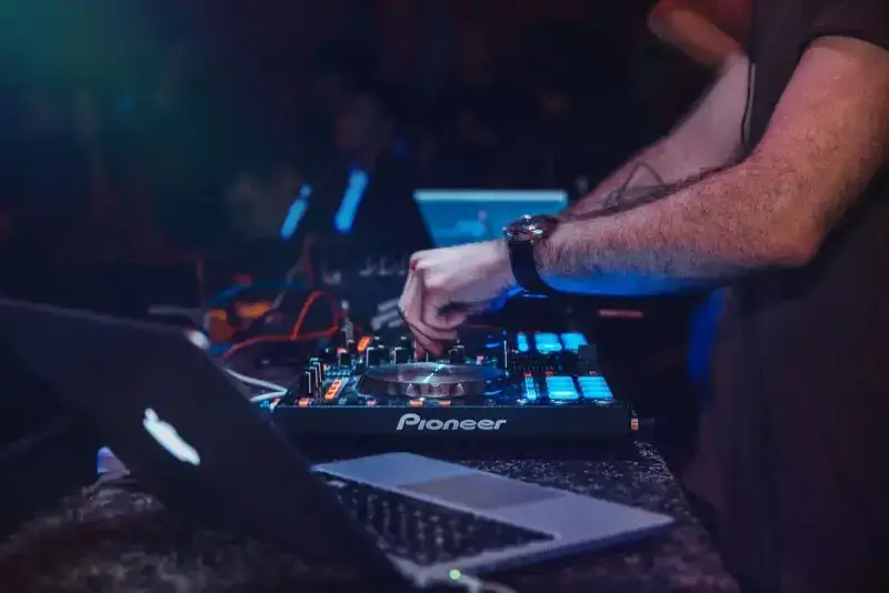 DJ mixing on a Pioneer controller during a club night