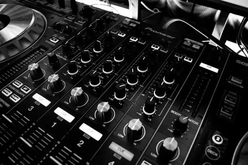 Close-up of a Pioneer DJ mixer and jog wheel in a dark club booth