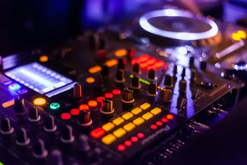 CDJ decks and mixer glowing in a dark club booth